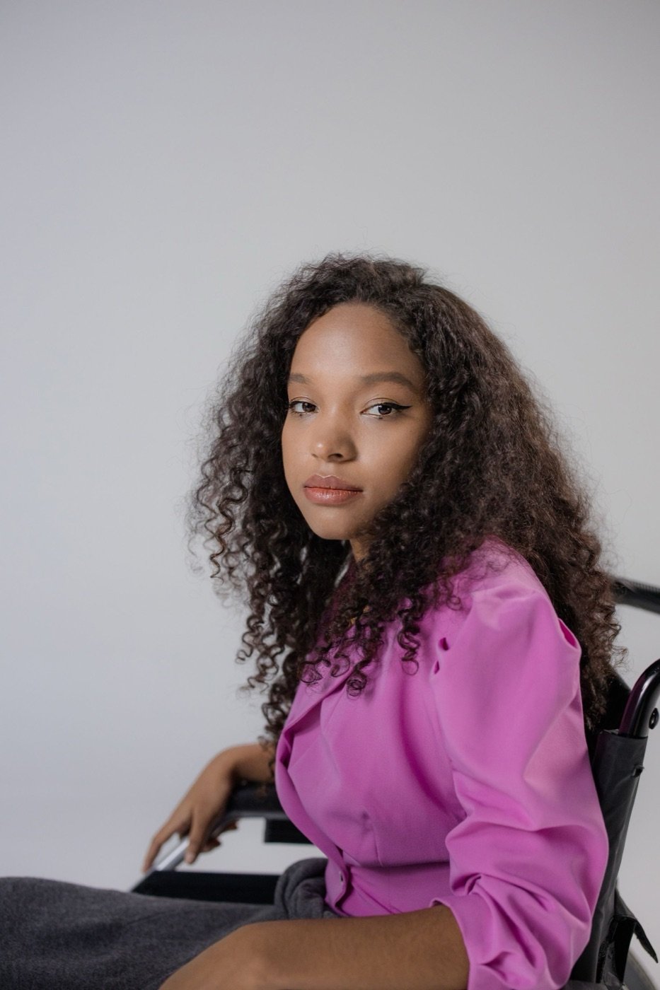 A person in a wheelchair in pink light