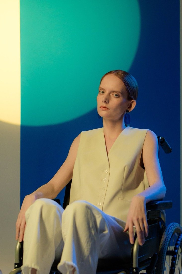 A woman in a wheelchair on teal and yellow light